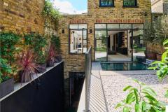 A grand house renovation and contemporary rear extension in Wandsworth, featuring London stock brickwork, steel-framed glazing and a landscaped courtyard.