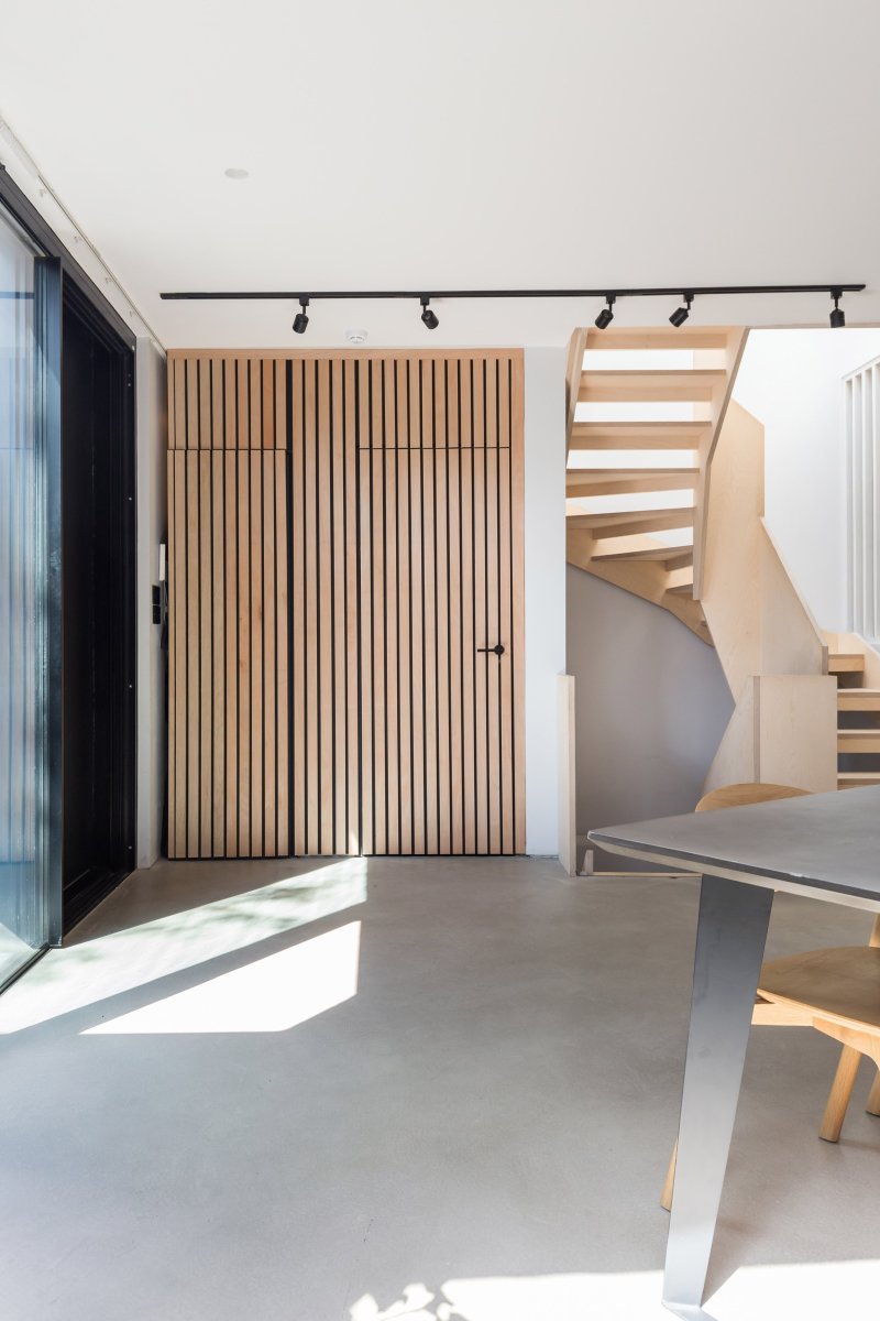 Birch staircase with open risers beside vertical timber screening in a new-build house in Forest Hill.