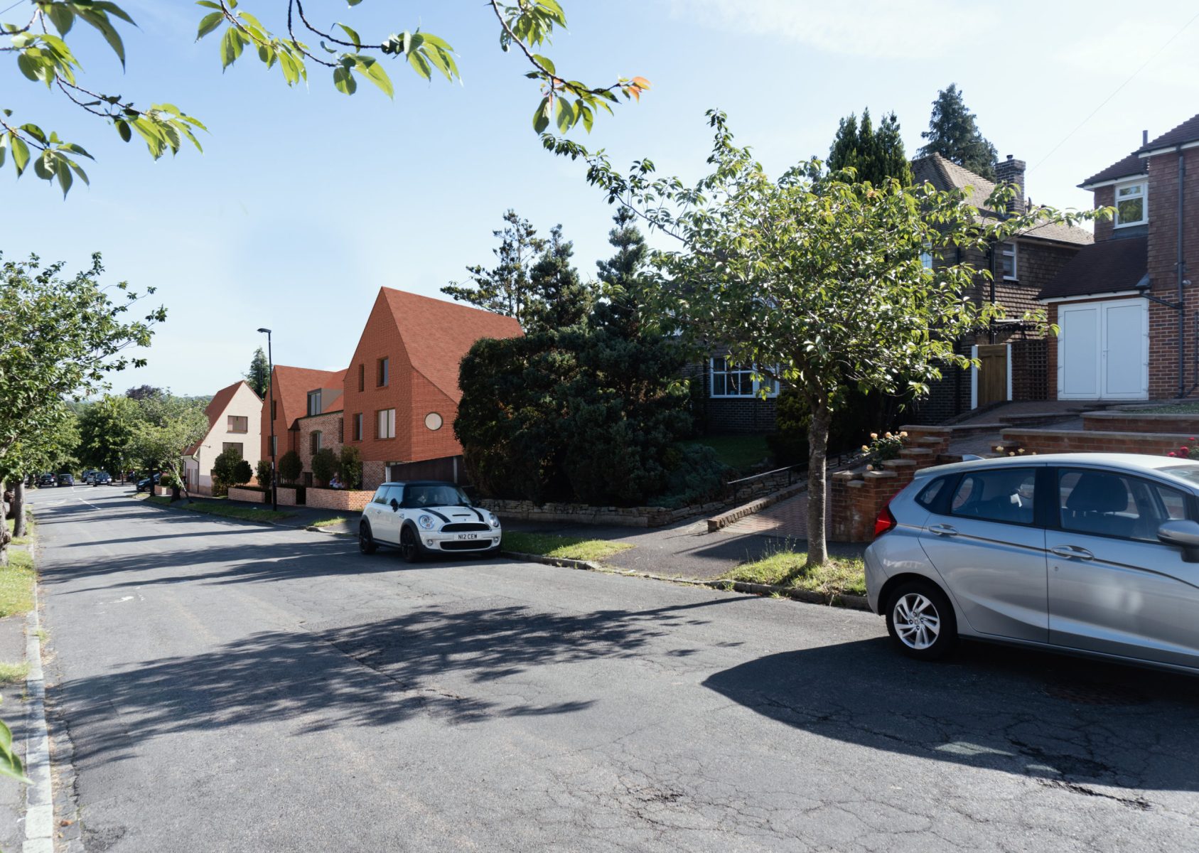 Street view of the new-build housing development at 158 Purley Downs Road, South Croydon, with pitched roofs and surrounding trees.
