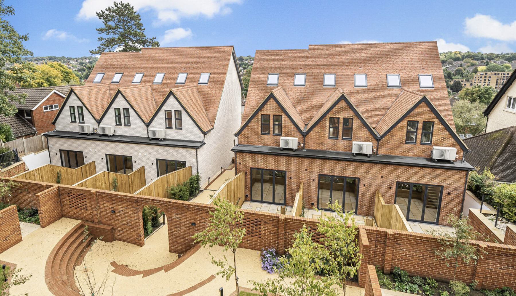 New-build houses in Coulsdon with gabled tiled roofs, brick and rendered façades, private terraces and landscaped outdoor areas.