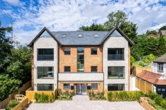 Nine new-build flats at 1 South Drive, South London, with twin gables, brick detailing and large windows.