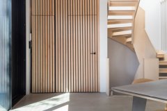 Birch staircase with open risers beside vertical timber screening in a new-build house in Forest Hill.