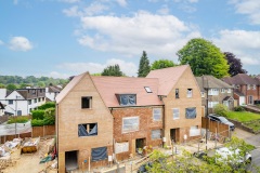 Street view of the new-build housing development at 158 Purley Downs Road, South Croydon, with pitched roofs and surrounding trees.