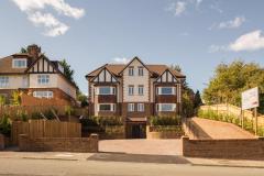 Front elevation of a nine-flat new-build development in South London, with brick and rendered façades.