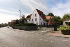 Street view of the new-build housing development at 158 Purley Downs Road, South Croydon, with pitched roofs and surrounding trees
