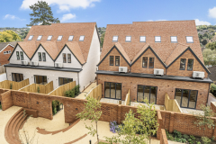 New-build houses in Coulsdon with gabled tiled roofs, brick and rendered façades, private terraces and landscaped outdoor areas.