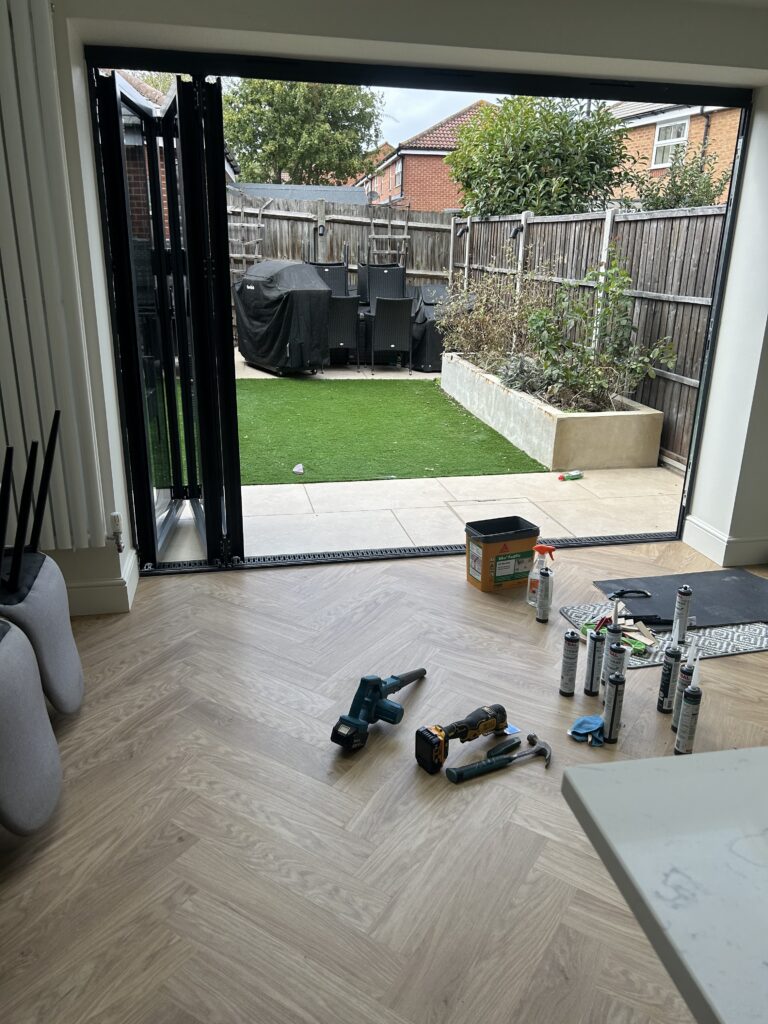 Häcker kitchen with central island, quartz worktops and Amtico herringbone flooring at Massingberd Way, Tooting.
