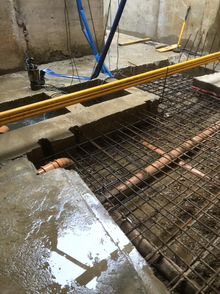 Submersible pump keeping the basement dry while reinforcement and below-slab drainage go in