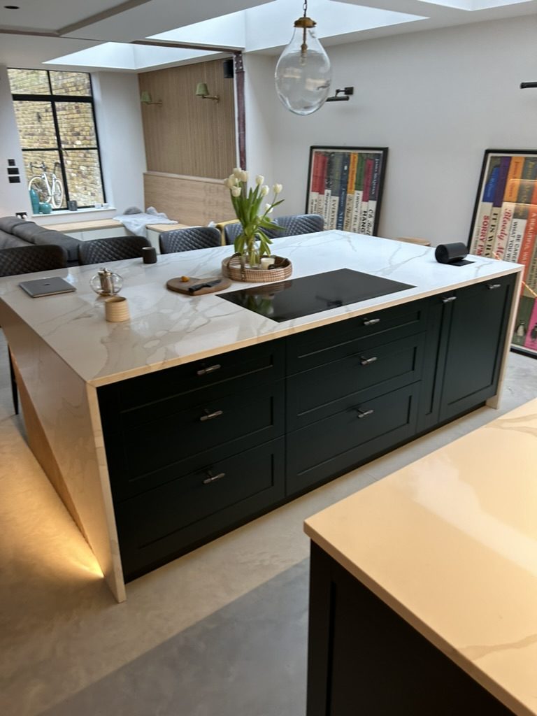 Kitchen island with waterfall-edge marble-effect worktop under rooflights