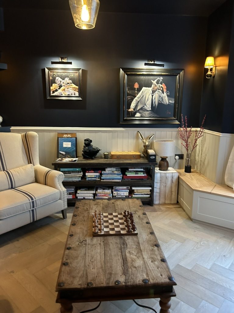 Snug with dark walls, tongue-and-groove panelling and herringbone oak floor