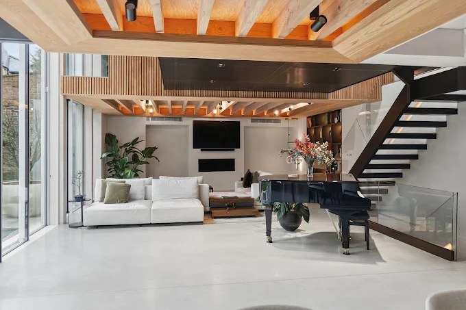 Open-plan living area with feature ceiling and glass-balustrade staircase